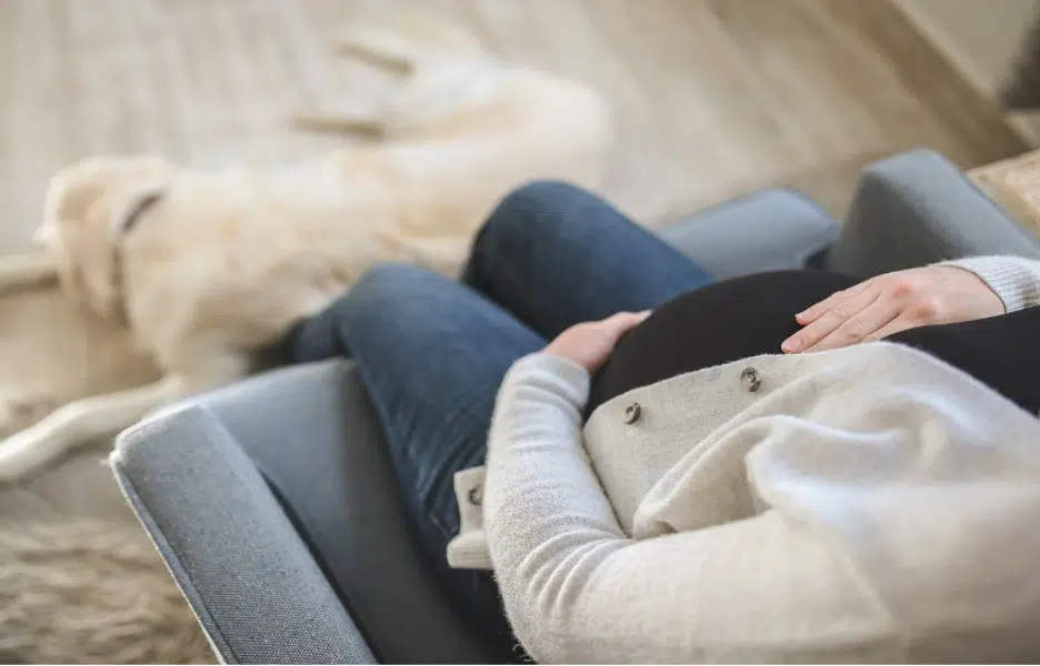 A pregnant woman sitting on a sofa