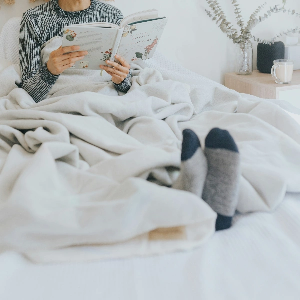 A person lying in bed reading a book