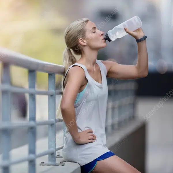 A girl drank water to recover after workout