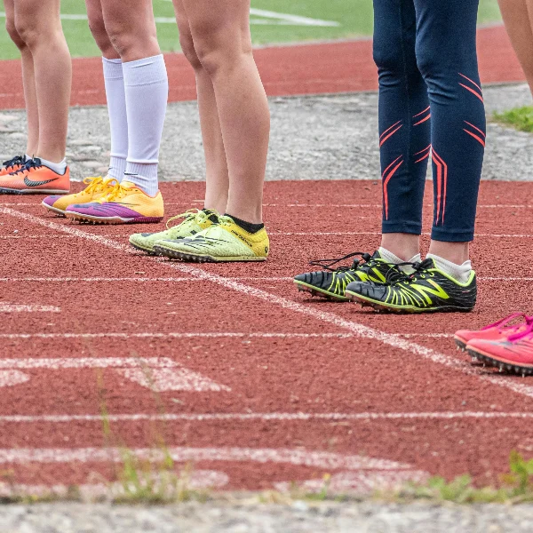 People wearing different types of compression socks wait at the starting line to start.