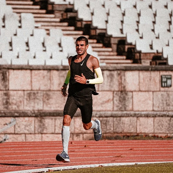 A man is running in compression socks and compression sleeves.