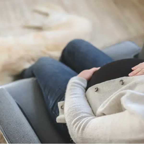 A pregnant woman sitting on a sofa