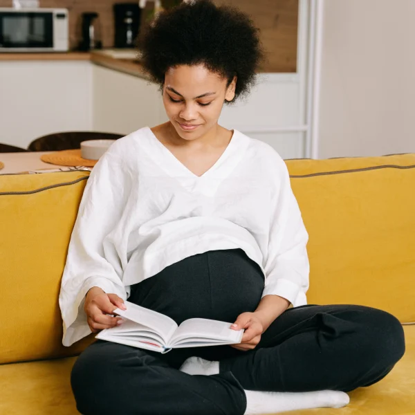 Pregnant woman in compression socks on the sofa